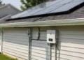 Solaranlage auf einem Hausdach mit Photovoltaikmodulen und Wechselrichter an der Hauswand.